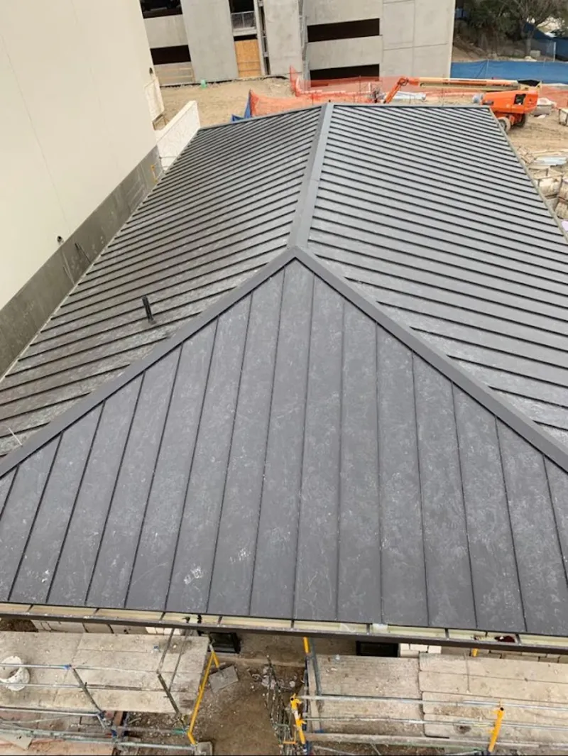 Commercial metal roof construction with crane equipment in Topeka